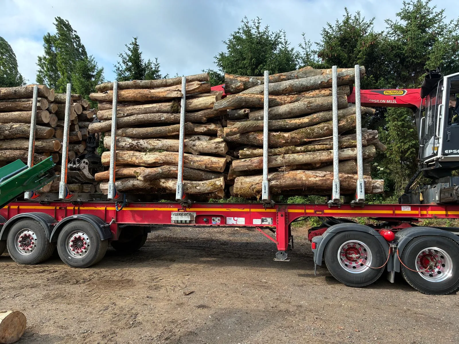 A tractor trailer loaded with logs and a load of logs.