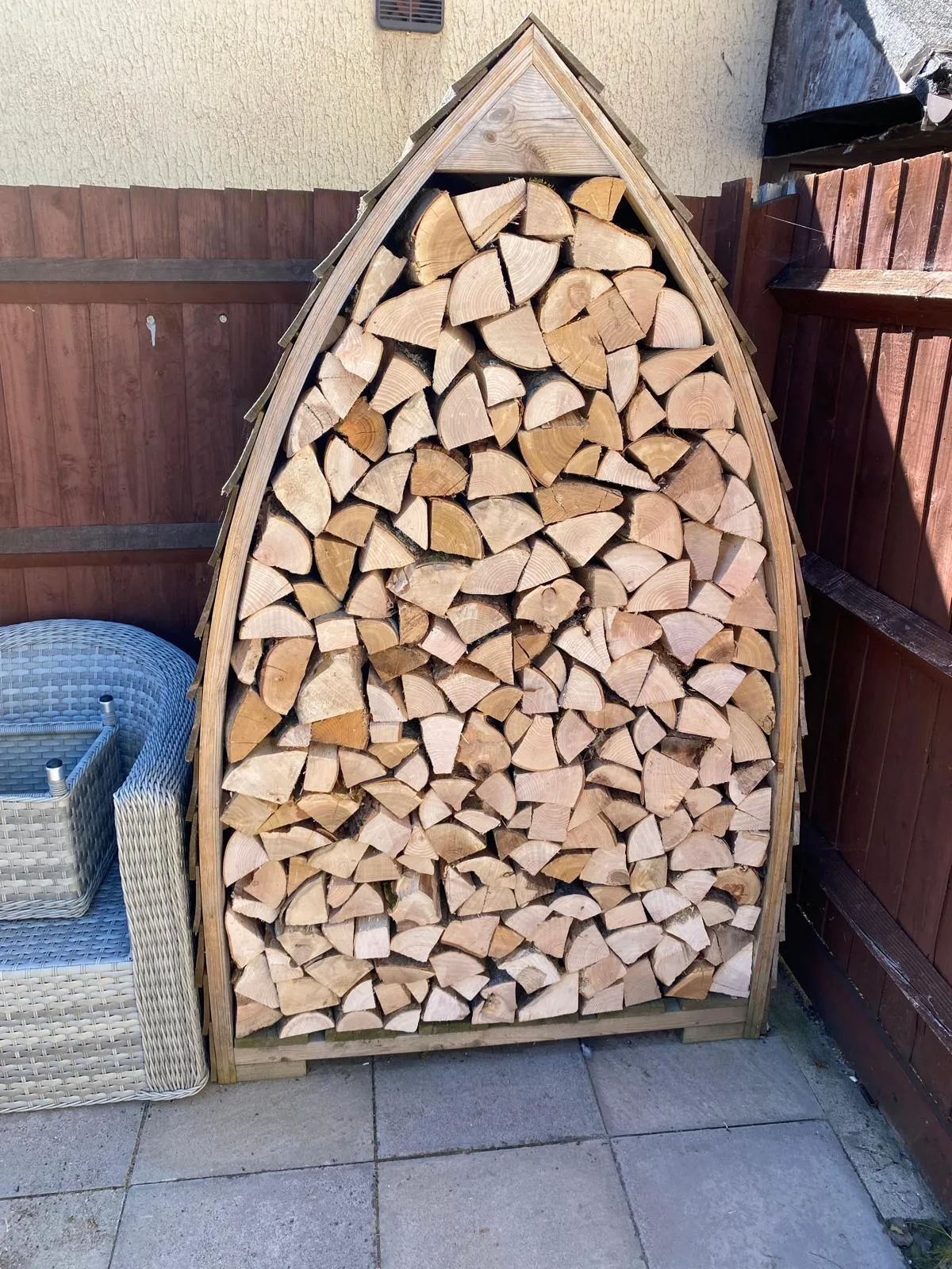 A boat made out of logs sitting on a patio.