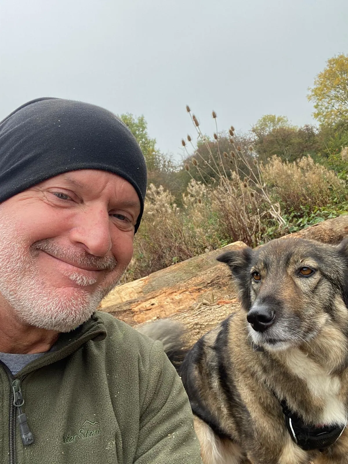 A man and a dog are smiling for the camera.